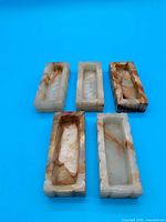 Top view of five onyx trays showing interior shape and veining