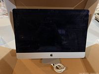 Front view of Apple iMac with power cable