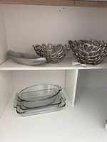 Shelf with two metal bowls, hammered tray, three stacked glass dishes