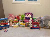 Group shot of all toys, books, games, plush, cash register and wooden rocker
