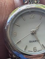 Front view showing white dial, gold-tone bezel, hour markers and hands