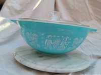 Side view of aqua Butterprint Cinderella bowl with clear lid