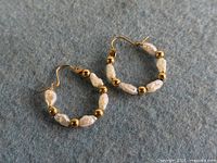 Both hoop earrings displayed flat showing bead and pearl pattern