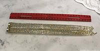 Pair of lucite candles beside ruler showing 12-inch length
