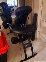 Front view of Earthlite portable massage chair showing black frame and cushions
