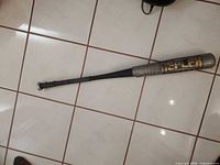 Full view of Reflex aluminum bat on tile floor