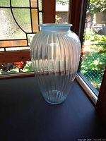 Full upright view of ribbed light blue opalescent vase