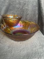 Large and small iridescent carnival glass bowls with metal stand