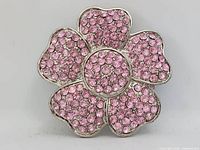 Front of silver-tone belt buckle showing five-petal flower design fully encrusted with pink rhinestones
