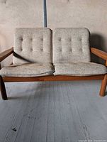 Front view of Domino Mobler teak loveseat showing full frame and cushions