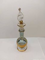 Full view of perfume bottle showing stopper and gold accents