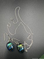 Entire chain with cross pendant and both dichroic glass earrings displayed