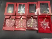 All four Mikasa crystal ornaments in open boxes showing designs and ribbons