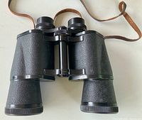 Front view of Halina binoculars showing textured body, focus wheel, neck strap