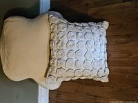 Front of square pillow with rosettes resting on butterfly lumbar pillow