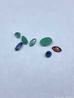 Seven assorted loose gemstones on white background