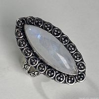 Front view of marquise rainbow moonstone ring with ornate bezel