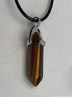 Front view of tiger eye pendant on cord