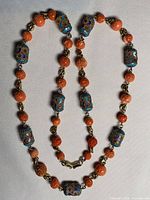 Full view of peach coral and cloisonné beaded necklace