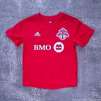 Front view of red Adidas Toronto FC youth jersey