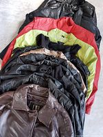 stack of assorted leather and faux leather jackets showing variety of colours and materials