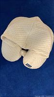 Front view showing hood extended over U-shaped pillow and brand tag