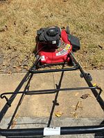 Top view showing Briggs & Stratton engine on red 20-inch deck with handle extended