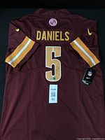 Back view of jersey showing DANIELS name, number 5, tags, authentication barcode