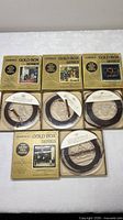 Group shot of all four Ampex Gold Box Series tapes with slipcases and reels