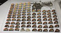 Group of rainbow enamel pins laid out with loose clutch backs