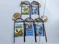 Five miniature garden flags on metal stands, front view