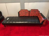 Full view of black vinyl daybed with patterned cushions