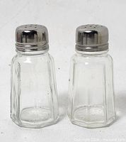 Front view of both glass shakers with metal tops