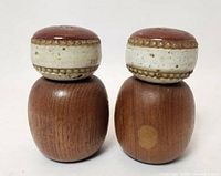 Front view of both shakers showing wood bodies and ceramic tops