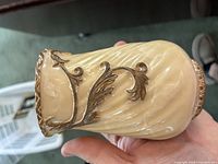 Right profile of cream stone vase showing goldtone leaf scroll