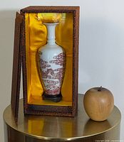 Vase seated in silk-lined brocade box with stand visible