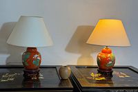 Both lotus-decorated porcelain lamps on tables showing shades and bases