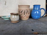 All four pottery pieces on tabletop