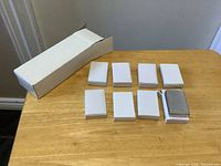 Outer carton with eight individual white boxes, one open, displaying lighters