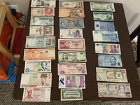 Overall view of 28 foreign banknotes laid out in four columns on a table