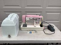 Overall view of sewing machine with case, foot pedal, accessories