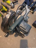 Overall view of folded green corded miter saw with 10-inch blade guard