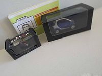 Two boxed items: larger Smart City-Coupé model and smaller boxed miniature car, plus booklet