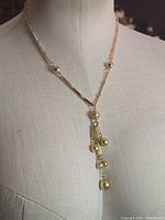 Full view of gold-tone necklace on mannequin, showing overall length and design