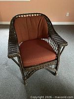 Front view of wicker armchair showing upholstery and wicker arms