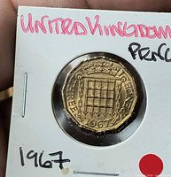 Reverse of 1967 UK threepence brass coin in holder