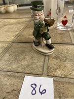Front view of porcelain leprechaun figurine playing trumpet
