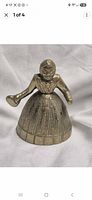 Front view of brass lady bell showing figure detail and ribbed skirt bell body