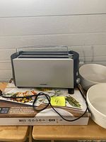 Front view of Cloer toaster on top of boxed Trudeau platter set with two white bowls