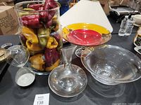 Group view of all glass items including vase with peppers, hourglass, carafe, compote bowl, serving bowl